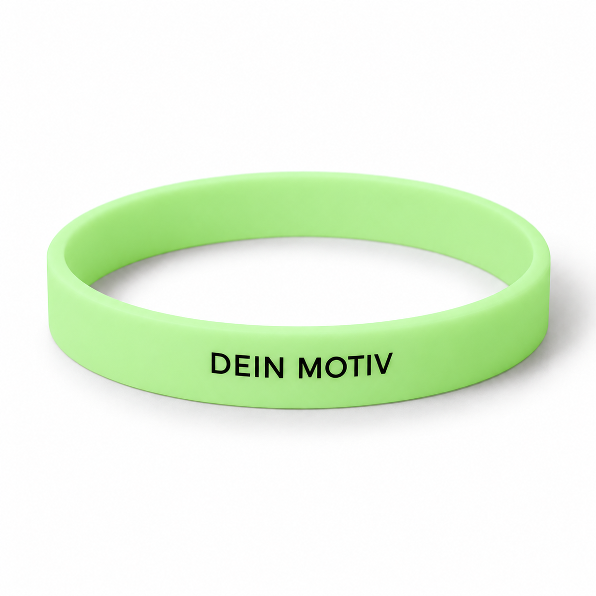 Hellgrünes leuchtendes Silikonarmband mit schwarzem Beispielmotiv „Dein Motiv“ bei Tageslicht – eigene Visualisierung